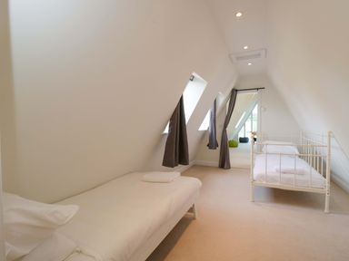 A bedroom with beds and windows at Lady Of Lourdes in Whitchurch, Herefordshire