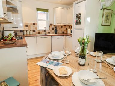 A kitchen with a table set for dining at Rodwell Holt in Weymouth