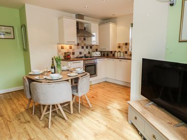 A dining room with a table set for meals at Rodwell Holt in Weymouth