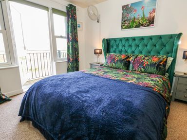 A bedroom with a green bed and lamps at Rodwell Holt in Weymouth
