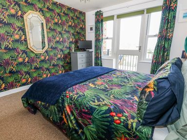 A bedroom with a bed and dresser at Rodwell Holt in Weymouth