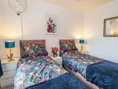 A bedroom with two beds and a flower vase at Rodwell Holt in Weymouth