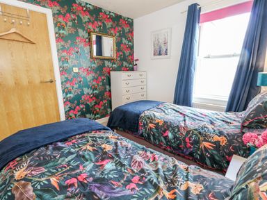A bedroom with two beds and a dresser at Rodwell Holt in Weymouth