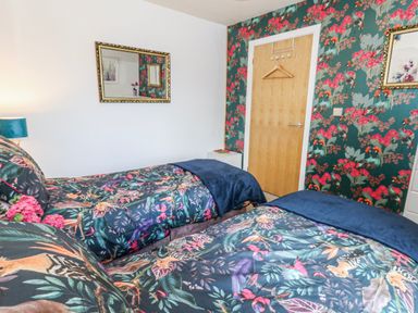 A bedroom with two beds and a mirror at Rodwell Holt in Weymouth
