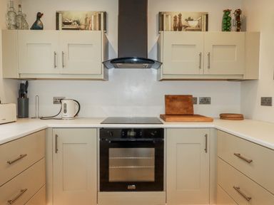 A kitchen with cabinets and cooker at Cove Retreat in Penzance