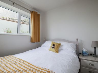 A bedroom with a bed and nightstand at Cove Retreat in Penzance