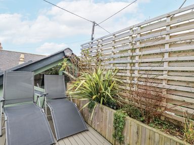 An outdoor area with deck chairs and a planter at Cove Retreat in Penzance