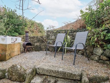 A garden with two chairs and a fire pit at Cove Retreat in Penzance
