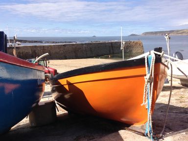 A harbor scene with boats and a tractor at Cove Retreat Sennen Cove