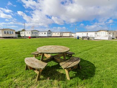 An outdoor area with a picnic table and caravans at St Michaels Caravan Park - 236 Towyn