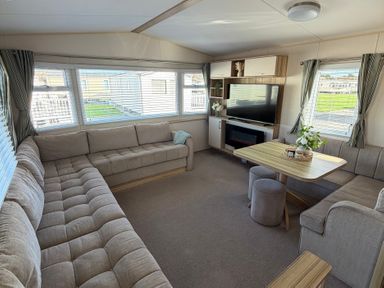 A living room with a sofa and coffee table at The Beachside Hideout - St Michaels Caravan Park Towyn