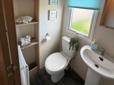 A bathroom with a toilet and sink at The Beachside Hideout - St Michaels Caravan Park Towyn
