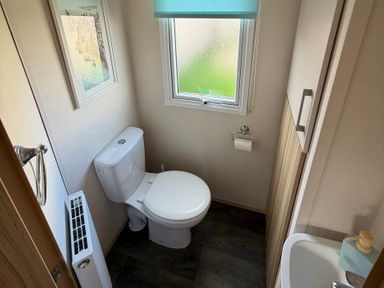 A bathroom with a toilet and sink at The Beachside Hideout - St Michaels Caravan Park Towyn