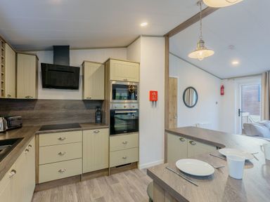 A kitchen with appliances and stools at Brayford Lodge (Pet) Louth