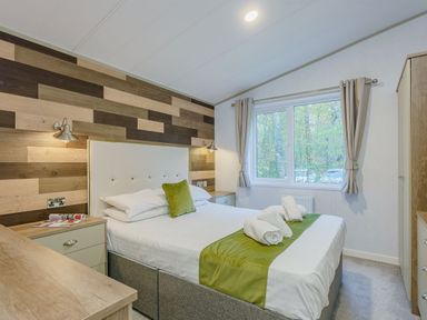 A bedroom with a bed and wooden features at Brayford Lodge (Pet) in Louth