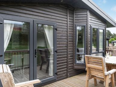 An outdoor patio with wooden decking and furniture at Brayford Lodge (Pet) in Louth