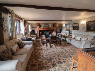 A living room with a sofa and dining table at Winston Lodge in Beccles