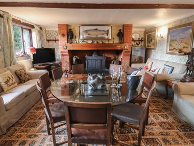 A living room with a dining table and sofa at Winston Lodge in Beccles