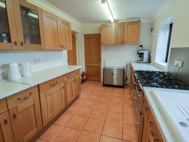 A kitchen with cabinets and a stove at Winston Lodge in Beccles