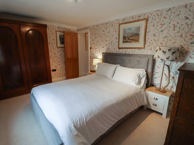A bedroom with a bed and wardrobe at Winston Lodge in Beccles
