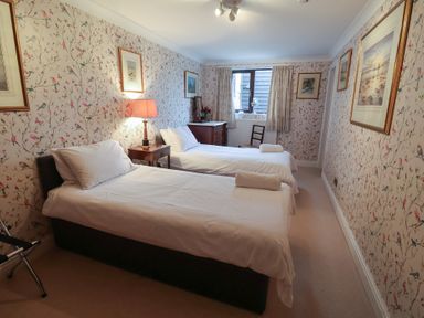 A bedroom with two beds and a table at Winston Lodge in Beccles