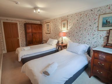 A bedroom with two single beds and a wardrobe at Winston Lodge in Beccles
