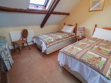 A bedroom with two beds and a lamp at Winston Lodge in Beccles
