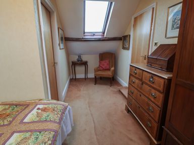 A bedroom with a bed, chair, table, and drawer at Winston Lodge in Beccles
