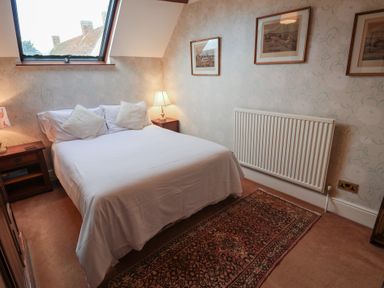 A bedroom with a bed and lamp at Winston Lodge in Beccles