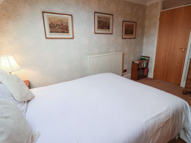 A bedroom with a bed and lamp at Winston Lodge in Beccles