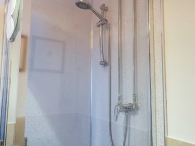 A shower with a faucet and showerhead at Winston Lodge in Beccles