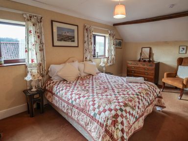 A bedroom with a double bed and dresser at Winston Lodge in Beccles