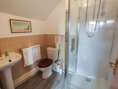 A bathroom with a sink, toilet, and shower at Winston Lodge in Beccles