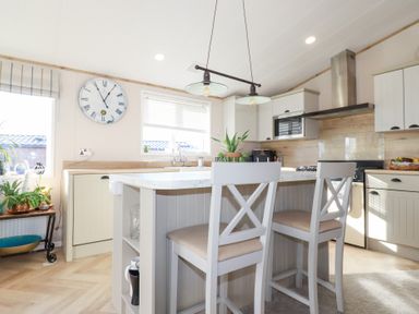 A kitchen with an island and stools at FW4 (Fairways 4)