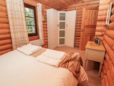 A bedroom with a bed and wardrobe at Little Bears Hideaway @ 23 Lakeside Felmoor Park near Felton