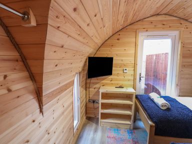 A bedroom with wooden walls and a television at Park View Lodge