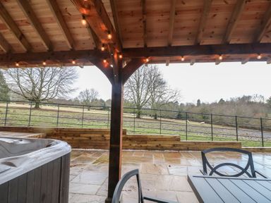 An outdoor area with a hot tub and furniture at Park View Lodge