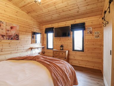 A bedroom with wooden walls and a bed at The Sty in Hatton, Derbyshire