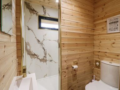 A bathroom with a shower, sink, and toilet at The Sty in Hatton, Derbyshire
