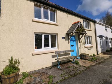 A house with a blue door and bench at 1 Mill Farm Cottages Narberth
