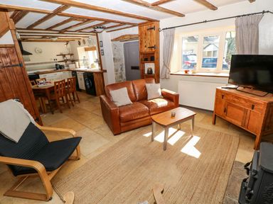A living room with a sofa and television at 1 Mill Farm Cottages in Narberth