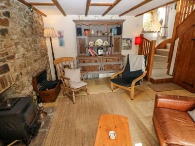 A living room with a rocking chair and a coffee table at 1 Mill Farm Cottages Narberth