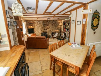 A kitchen with dining table and sofa at 1 Mill Farm Cottages in Narberth