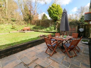 A garden with a table and chairs at 1 Mill Farm Cottages in Narberth