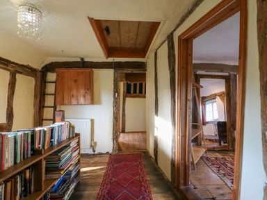 A hallway with a bookshelf and staircase at Town Farm in 