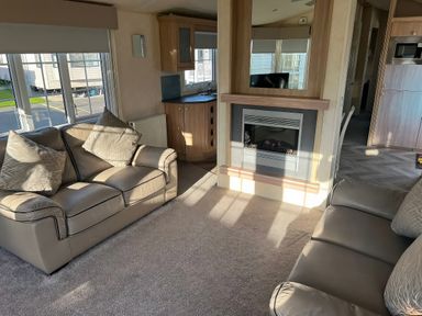 A living room with sofas and a fireplace at Gainc Bach in Abergele