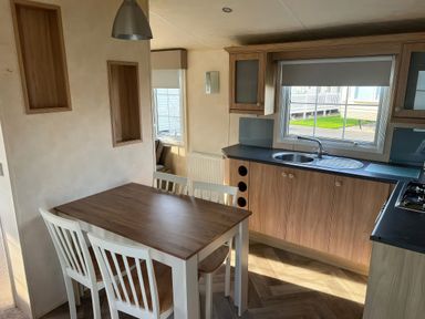 A kitchen with a dining table and chairs at Gainc Bach in Abergele