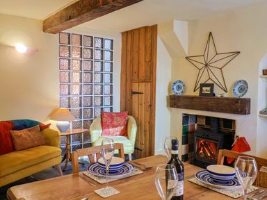 A dining room with a table set for a meal at Rope Cottage in Bridport