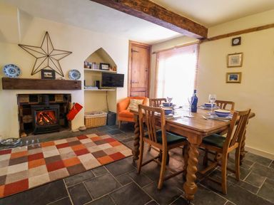 A dining room with a table and chairs at Rope Cottage in Bridport