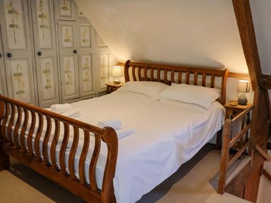A bedroom with a bed and wardrobe at Rope Cottage Bridport